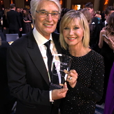 Olivia Newton-John with John Farrar and his award